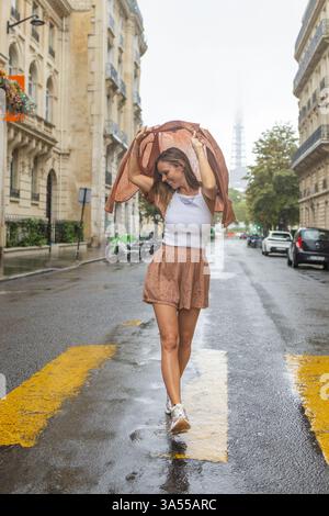 Donna che balla in una giornata nebbiosa in mezzo alla strada di Parigi Foto Stock