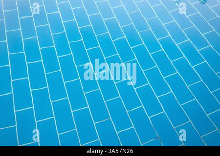 Sfondo della piscina con piastrelle leggermente distorte sotto la superficie dell'acqua Foto Stock