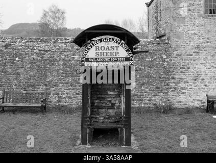 Eham, Chesterfield, Regno Unito - 21 marzo 2025 - Una foto in bianco e nero di un piccolo edificio con un cartello che dice Roasting Roast Sheep Foto Stock