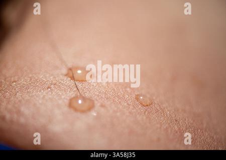 Una foto macro estremamente dettagliata che cattura gocce d'acqua scintillanti sulla pelle liscia, evidenziando texture, freschezza e bellezza naturale. Foto Stock
