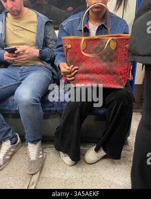 LOUIS VUITTON X YAYOI KUSAMA MONOGRAM TELA ROSSA A PUNTINI INFINITO NEVERFULL MM borsa a mano firmata portata sulla metropolitana di londra inghilterra 2025 Foto Stock