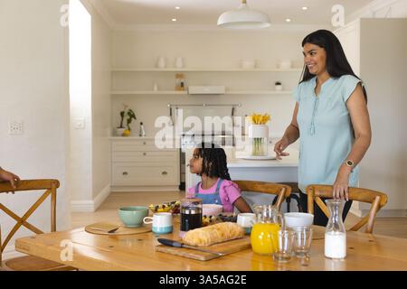 Madre e figlia si godono la colazione insieme a casa, condividendo momenti di gioia Foto Stock