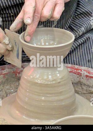 Primo piano delle mani che lavorano sulla ruota di potter Foto Stock