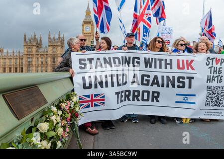 Westminster Bridge, Londra, Regno Unito. 22 marzo 2025. In occasione dell'ottavo anniversario dell'attacco terroristico del ponte di Westminster, che ha ucciso 5 persone e ferito 48, gruppi di attivisti anti-terrorismo, Stop the Hate and Our Fight, hanno tenuto una commemorazione sul ponte di Westminster per unire contro il terrorismo e ricordare le vittime. Crediti: Amanda Rose/Alamy Live News Foto Stock