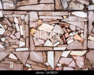 Muro di tufo rosa armeno e frammenti di marmo bianco nella città di Erevan Foto Stock