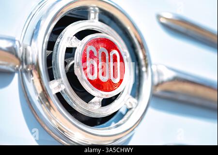 Larnaca, Cipro - 12 maggio 2024: Logo cromato FIAT 600 che risplende sulla superficie dell'auto azzurra, riflettendo la luce del sole e sottolineando l'eleganza dell'auto d'epoca Foto Stock