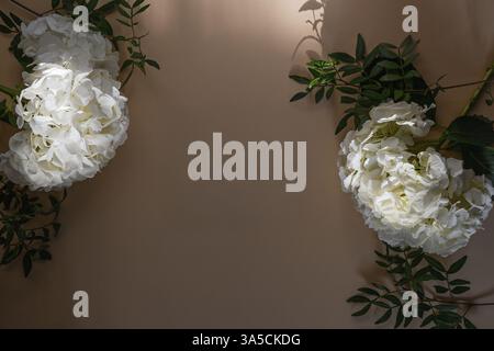 Ortensie bianche con candele su sfondo beige. Romantico, bellissimo sfondo di fiori di ortensia pastello con spazio per il testo. Foto Stock