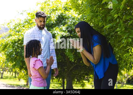 La famiglia si diverte all'aria aperta e mamma e figlia condividono momenti di gioco nel parco Foto Stock