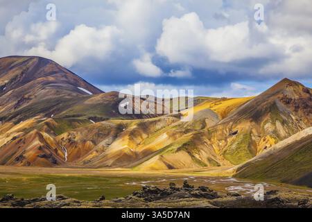 Multi-montagne colorate da minerali di riolite sono illuminati con sun. Viaggio in Islanda in luglio. Estate tundra vulcaniche Foto Stock
