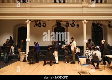I migranti stanno ricevendo tagli di capelli al centro di accoglienza settimanale degli immigrati della chiesa di San Marco in-the-Bowery. Ogni settimana, la St. Mark's Church in-the-Bowery di Manhattan, New York, fornisce consulenza legale e amministrativa e distribuisce le necessità di base a dozzine di immigrati, per lo più richiedenti asilo nell'Africa occidentale. Prima dell'inaugurazione di Donald Trump il 20 gennaio, scuole, ospedali e chiese erano considerati "luoghi sensibili" che non potevano essere presi di mira dalle operazioni di immigrazione e di applicazione delle dogane. Ma il giorno dopo la sua entrata in carica, l’amministrazione Trump ha posto fine a questa politica trentennale, Leav Foto Stock