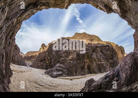 Obiettivo fisheye fotografato. Canyon nero nelle antiche montagne di Eilat. Arenaria arancione e rosa calda bagliore al sole Foto Stock