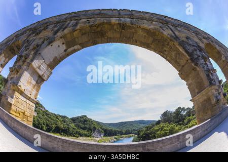 Parte del ponte. Una campata del ponte è rappresentata da un obiettivo fotografato Fisheye. Acquedotto a tre livelli Pont du Gard - il più alto d'Europa. Provenza, sole primaverile Foto Stock