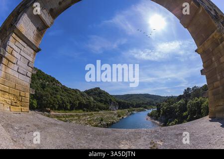 Parte del ponte. Una campata del ponte è rappresentata da un obiettivo fotografato Fisheye. Acquedotto a tre livelli Pont du Gard - il più alto d'Europa. Provenza, sole primaverile Foto Stock