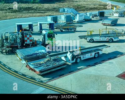 Cancun, Quintana Roo, Messico – 26 novembre 2024: Attrezzature di supporto a terra e container di carico sono pronti sull'asfalto dell'aeroporto internazionale di Cancun Foto Stock