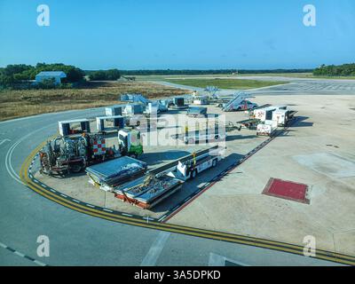Cancun, Quintana Roo, Messico – 26 novembre 2024: Attrezzature di supporto a terra e container di carico sono pronti sull'asfalto dell'aeroporto internazionale di Cancun Foto Stock