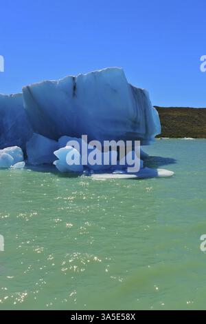 Enormi iceberg bianco-blu galleggiano vicino a una nave. Ghiaccio e sole in Patagonia. Escursione in barca turistica sul lago Viedma Foto Stock