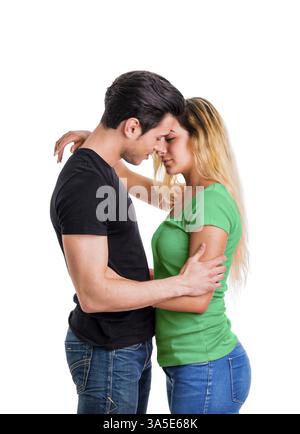 Coppia giovane in amore, coccole, abbracciando e baciando, studio shot su sfondo bianco Foto Stock