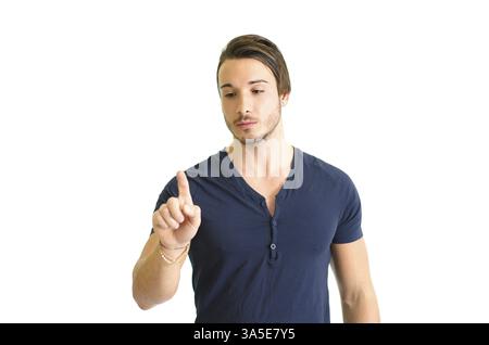 Attraente giovane premendo il pulsante immaginario in aria con il suo dito. Isolato su bianco Foto Stock