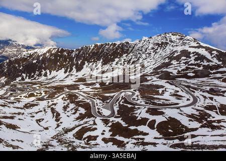 La prima neve cadde sulla Grossglockner Alpine Road. Austria. Ripida curva lastricata di pietra. La strada è recintata. La strada è composta da 36 giri a serpentina. E Foto Stock