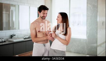 Coppia eccitata rivela Happy News con test di gravidanza positivo Foto Stock
