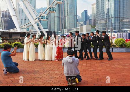 HONG KONG, 11 DICEMBRE 2014: Regione amministrativa speciale di Hong Kong. Matrimonio giovanile fotografato in un parco pubblico vicino alla ruota panoramica. Il moderno c Foto Stock