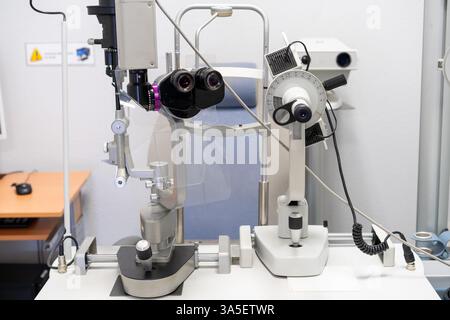 Primo piano di una lampada a fessura in una clinica oftalmologica utilizzata per esaminare gli occhi. Questo microscopio specializzato illumina e ingrandisce le strutture oculari. Foto Stock