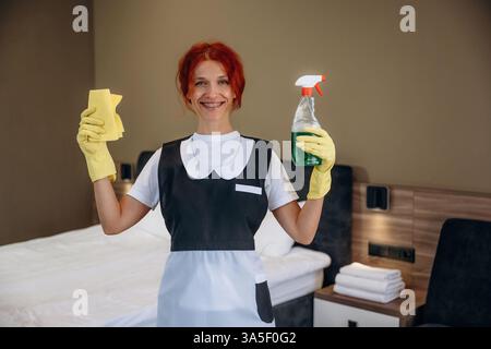 Pronti a pulire il posto. La cameriera lavora in una moderna camera d'hotel. Foto Stock