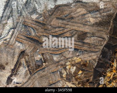 vista dall'alto dall'alto verso il basso dei cingoli sporchi del bolldozer nella sabbia Foto Stock