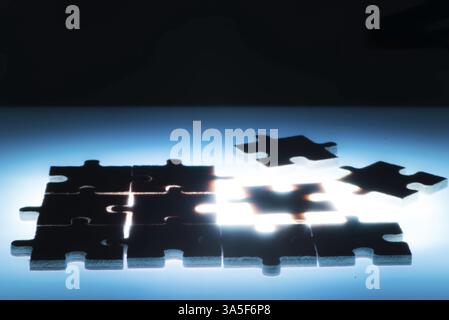 Puzzle in legno e la retroilluminazione dello sfondo. Close up. Colore blu luce Foto Stock