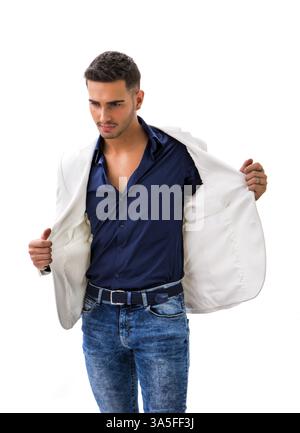 Bel Giovane Uomo in camicia blu, camicia bianca e jeans in posa isolati su sfondo bianco in studio Foto Stock