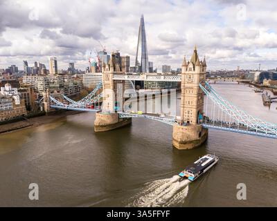 Vista aerea del Tower Bridge sul Tamigi a Londra con una nave turistica per passeggeri che passa sotto, mostrando The Shard sullo sfondo Foto Stock