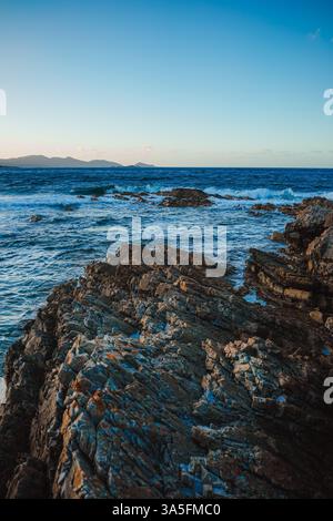 La Baia dei fuochi risplende: Rocce dalle tonalità arancio, onde turchesi e gabbiani che si innalzano fanno da cornice alla sinfonia costiera selvaggia della Tasmania. 🌊 Foto Stock