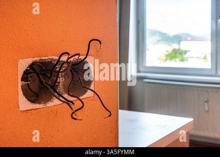 Ristrutturazione degli appartamenti. Cablaggio elettrico. Fili sporgenti dal muro. Cavi elettrici a parete nell'appartamento rete elettrica non finita Foto Stock