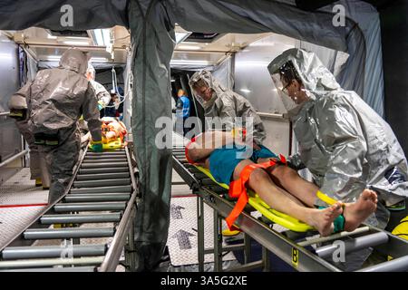 Dekontamination von Verletzten Personen nach einem angenommen Unfall mit Gefahrstoffen, Feuerwehr und Hilfsorganizationen üben den Aufbau und Betrieb eines Dekon-Platz, Verletzte werden gesichtet und dann in einem speziellen Duschzelt gewaschen um mögliche gefährliche Stoffe Einsatzkräfte belüftete Schutzanzügen Großübung Übung Foto Stock
