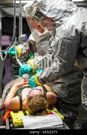 Dekontamination von Verletzten Personen nach einem angenommen Unfall mit Gefahrstoffen, Feuerwehr und Hilfsorganizationen üben den Aufbau und Betrieb eines Dekon-Platz, Verletzte werden gesichtet und dann in einem speziellen Duschzelt gewaschen um mögliche gefährliche Stoffe Einsatzkräfte belüftete Schutzanzügen Großübung Übung Foto Stock