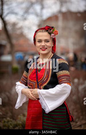 Kyustendil, Bulgaria – 15 febbraio 2025: Jamala Masquerade Festival. Una donna in costume tradizionale bulgaro, decorata con ricami e accesso Foto Stock