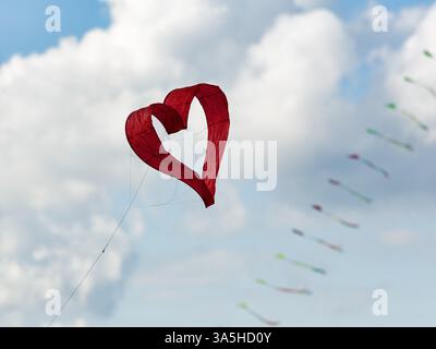 Aquilone a forma di cuore, cuore rosso, cielo nuvoloso, festival degli aquiloni a Vinsebeck, Steinheim, Eggegebirge e parco naturale della foresta di Teutoburgo meridionale, Weserberg Foto Stock