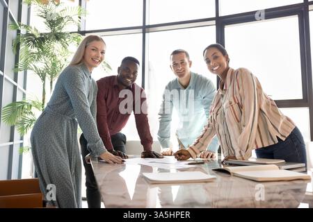 Un gruppo di professionisti multietnici si è riunito in una sala conferenze per eventi formativi, seminari educativi, brainstorming impegnati in attività produttive Foto Stock