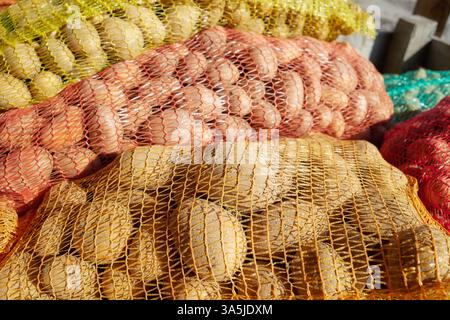 Patate biologiche in sacchetti di rete, focalizzazione selettiva. Foto Stock