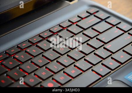 Primo piano di un'elegante tastiera per laptop con tasti retroilluminati rossi e un design moderno Foto Stock