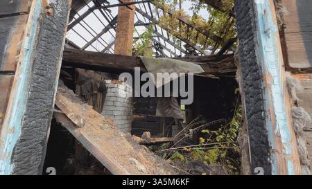 Resti di una casa di legno bruciata con camino in mattoni che rivelano un tragico incidente d'incendio Foto Stock