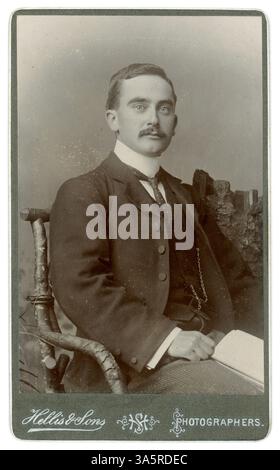 Carte de visite originale dell'epoca edoardiana o tardo vittoriana (biglietto da visita o CDV) di bel gentiluomo edoardiano /Victorian Gent con in mano un libro, baffi, studio Hellis & Sons, Londra, Regno Unito circa 1900 o 1901. Foto Stock