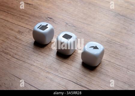 Tre dadi con l'icona mi piace, commento e condivisione. Concetto di social media. Foto Stock