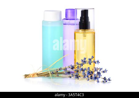 Mazzo di fiori di lavanda con gruppo di lozioni in bottiglie su sfondo bianco Foto Stock