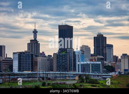 Paesaggio urbano di Johannesburg con il ponte Nelson Mandela che attraversa la ferrovia, la torre delle telecomunicazioni Hillbrow nello skyline della città, edifici del centro città sud A. Foto Stock