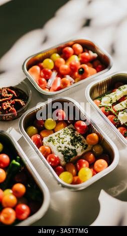 Una varietà di frutta e verdura è esposta in quattro diversi contenitori. I contenitori sono disposti in modo che siano tutti visibili e easi Foto Stock