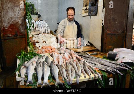 Fez, Marocco - 5 marzo 2014: Mercato tradizionale del pesce marocchino a Fez. Uomini che vendono pesci e frutti di mare. Foto Stock