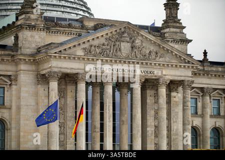 Berlino, Germania. 23 febbraio 2025. Bandiera tedesca e bandiera UE davanti al Bundestag. Foto Stock