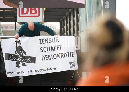Berlino, Germania. 23 febbraio 2025. Un uomo impicca uno striscione che dice (Zensur schafft Demokratie). Foto Stock