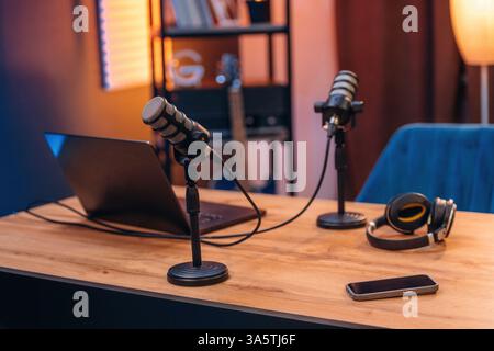 Microfoni, cuffie, smartphone e computer portatile sono sul tavolo, spazio per podcast. Foto Stock